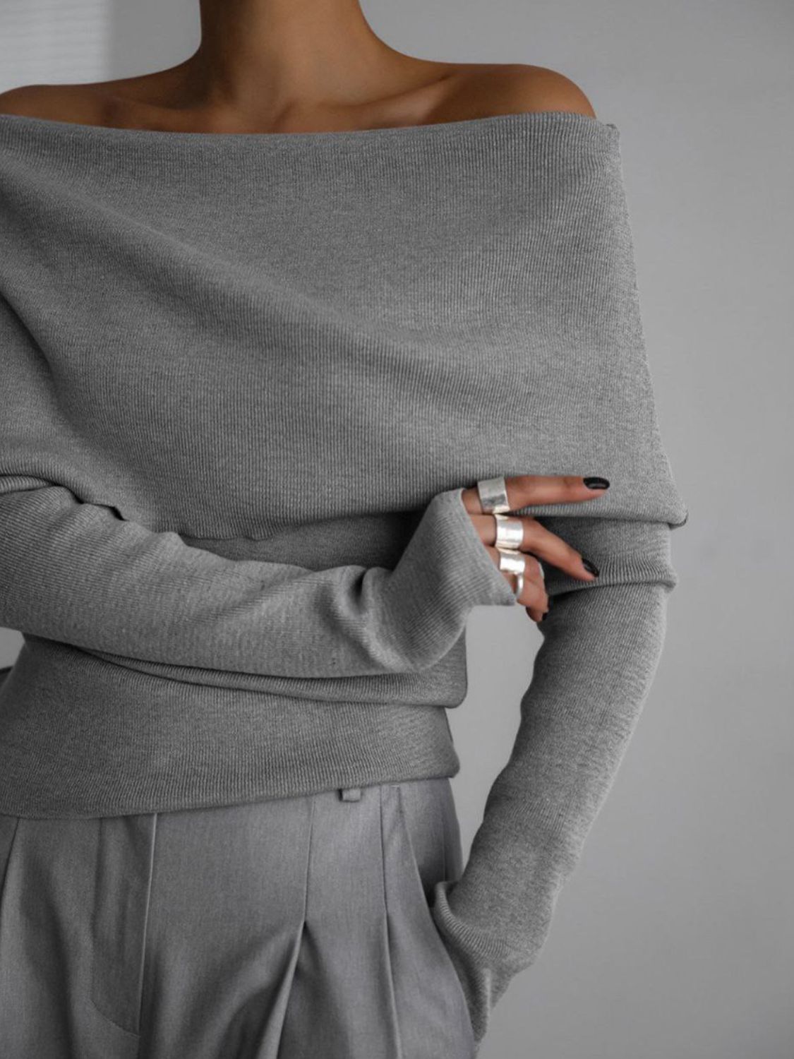 Woman wearing stylish gray off-shoulder long sleeve knit top