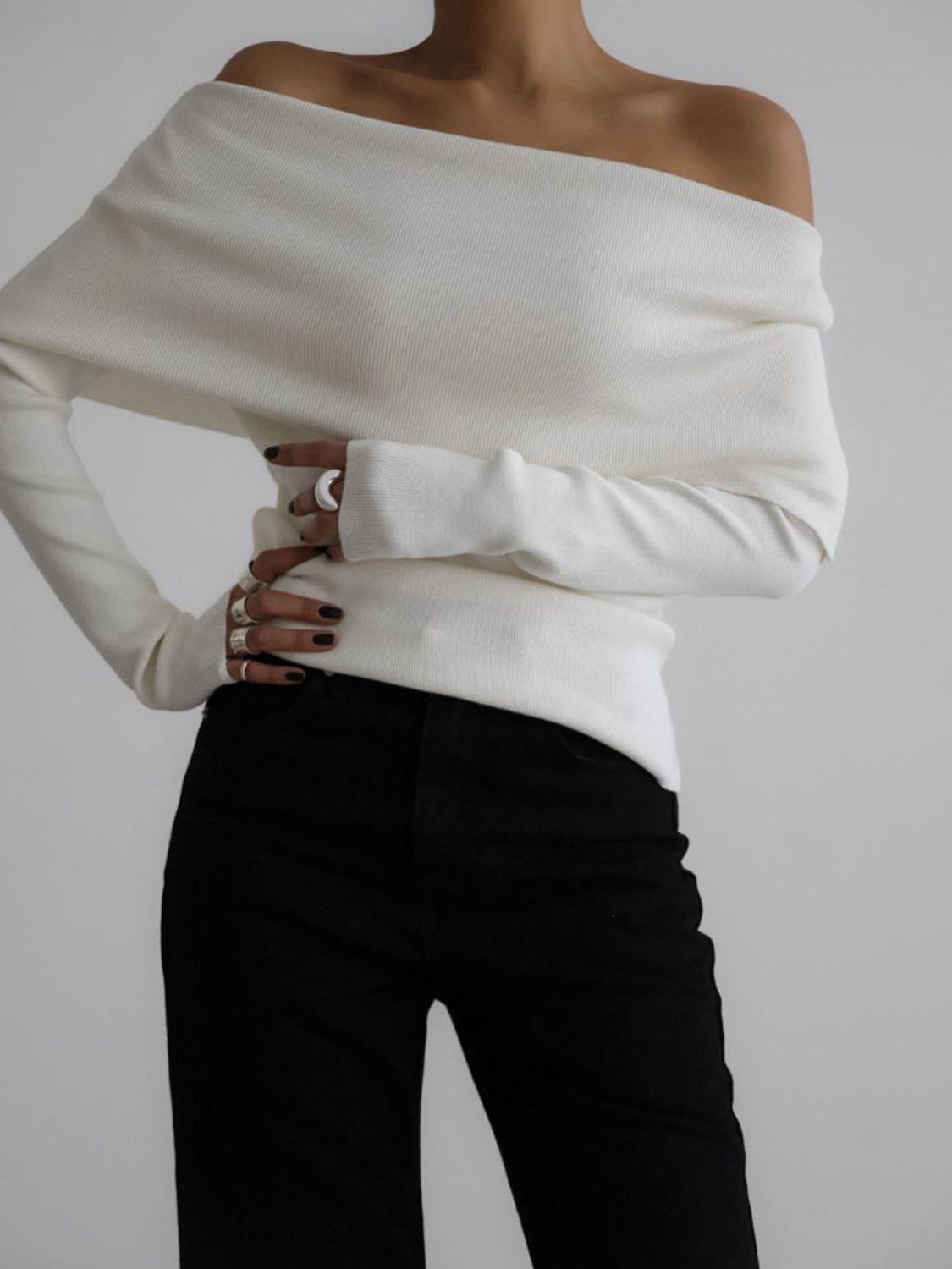 Woman wearing stylish white off-shoulder long sleeve knit top