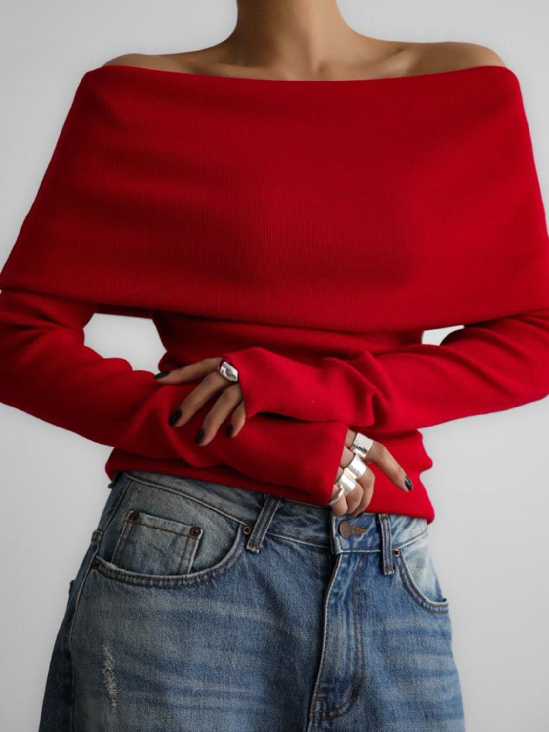 Woman wearing stylish red off-shoulder long sleeve knit top