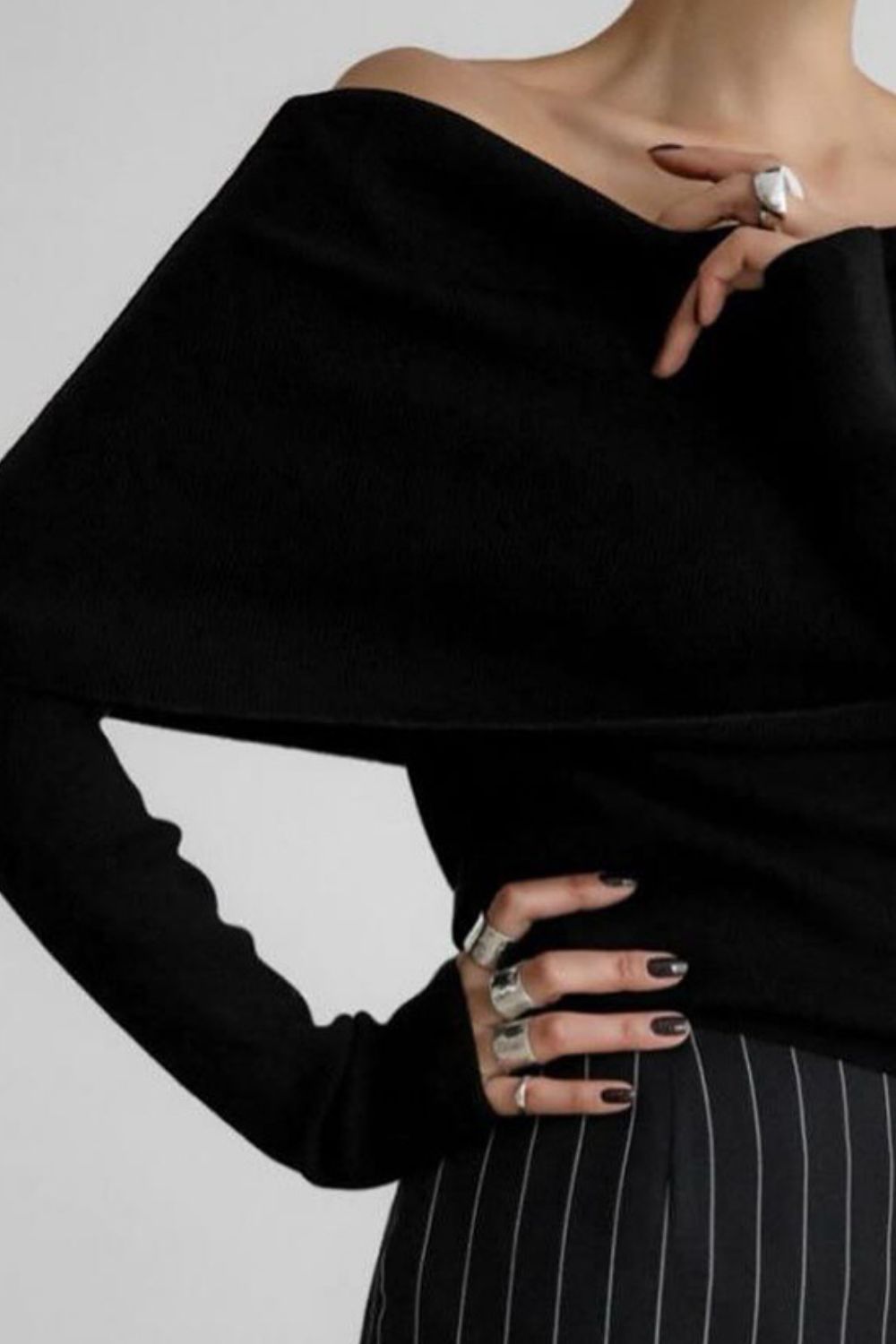 Woman wearing stylish black off-shoulder long sleeve knit top