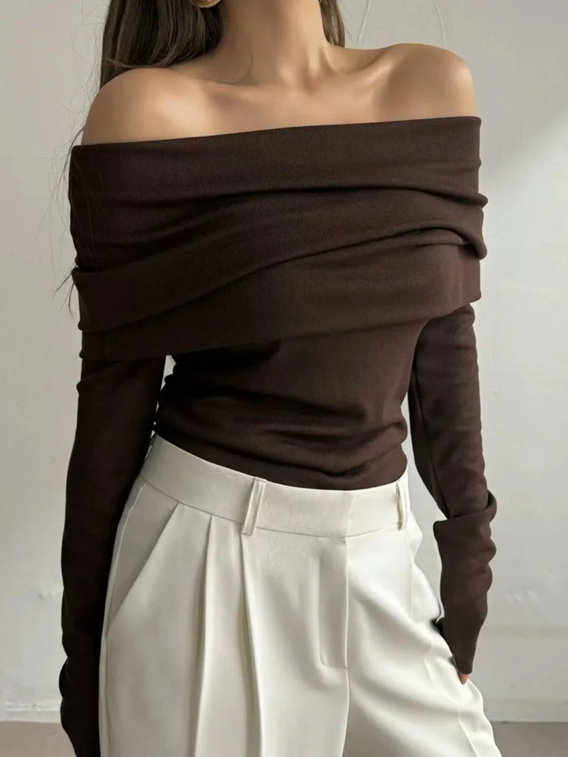 Woman wearing stylish brown off-shoulder long sleeve knit top