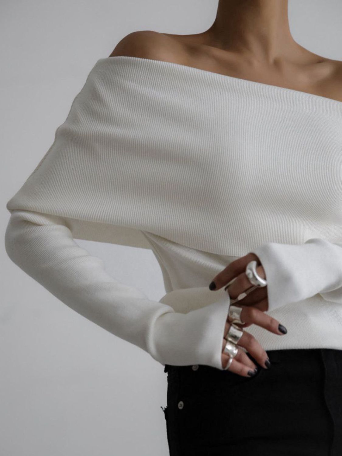 Woman wearing stylish white off-shoulder long sleeve knit top
