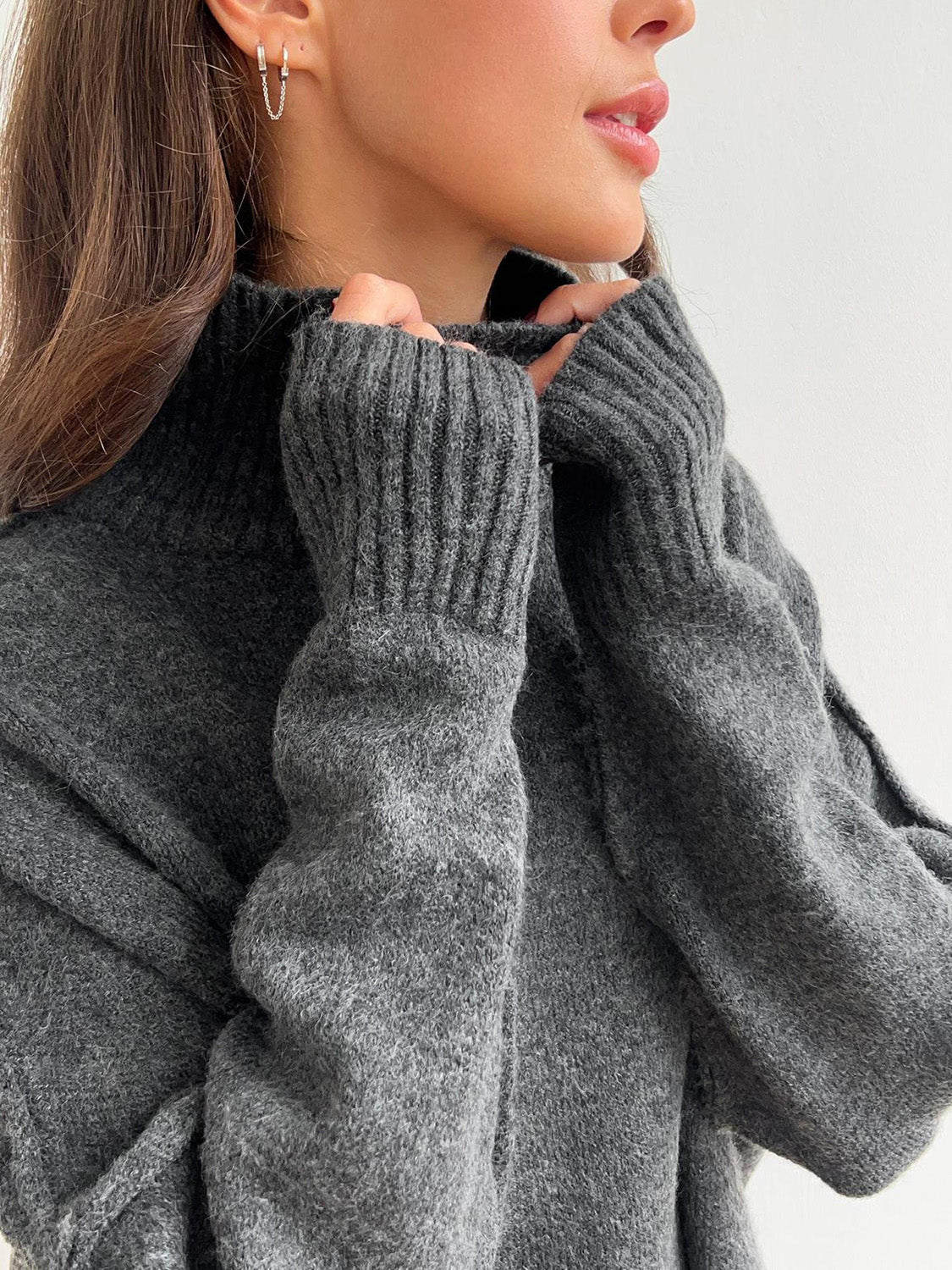 Model wearing cozy grey knit turtleneck and pants sweater set