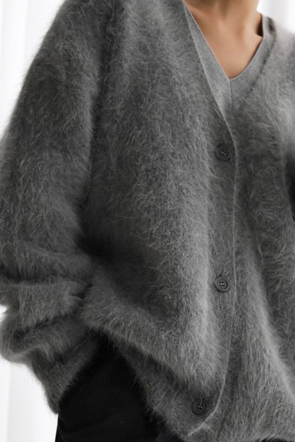 Woman wearing cozy grey fuzzy button down cardigan