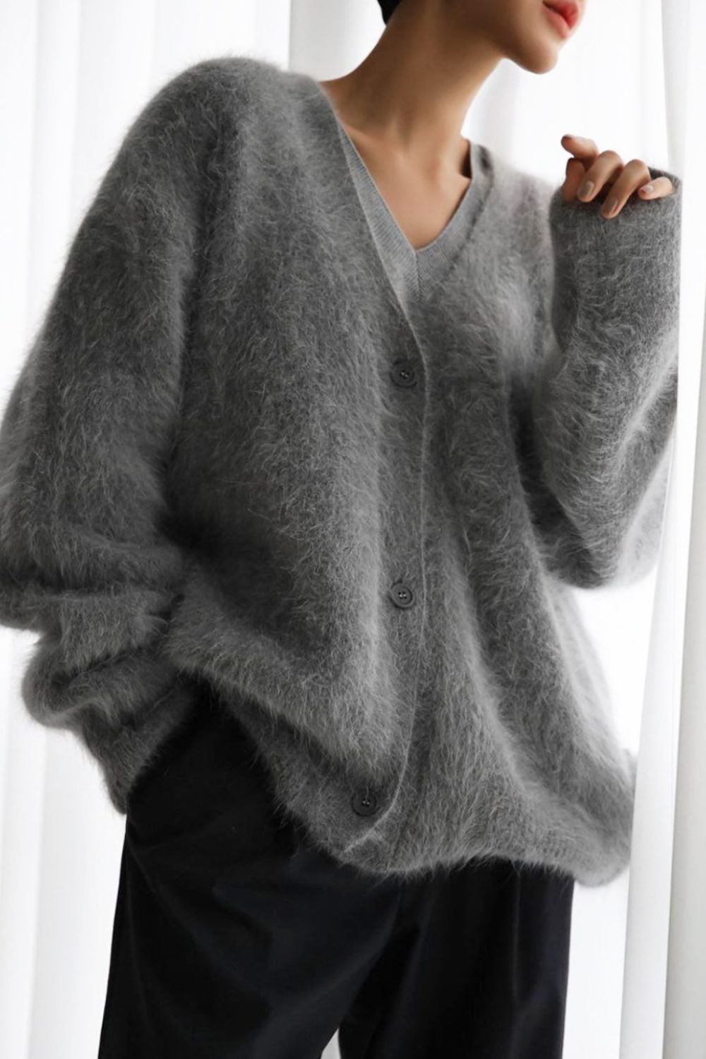 Woman wearing cozy grey fuzzy button down cardigan