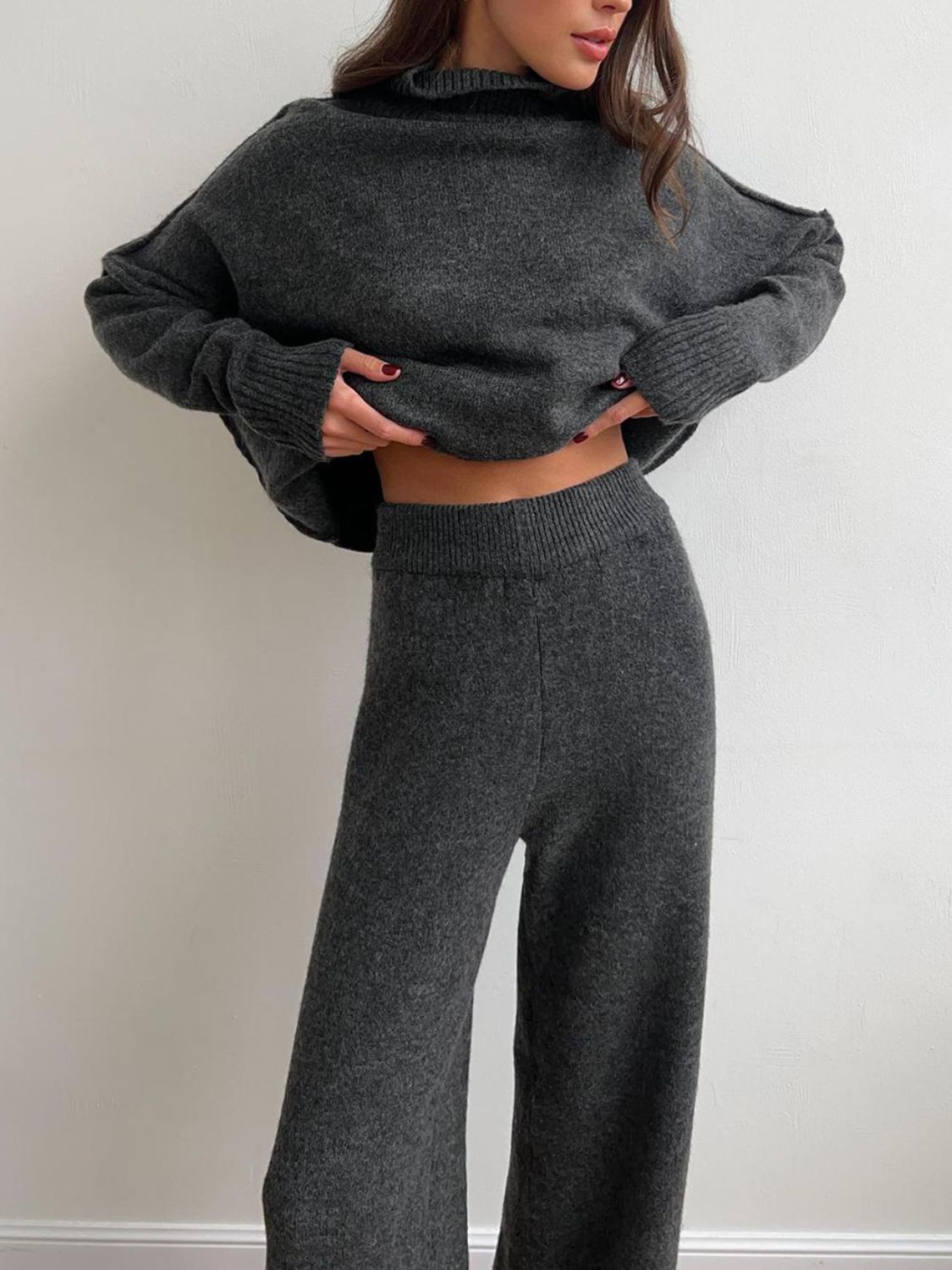 Model wearing cozy grey knit turtleneck and pants sweater set